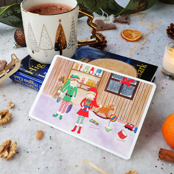 Petite affiche 10×15 “L’atelier du Père Noël” – tirage Fine Art Hahnemühle Hemp 290 g, deux lutins dans l’atelier avec jouets, vendue sans cadre.